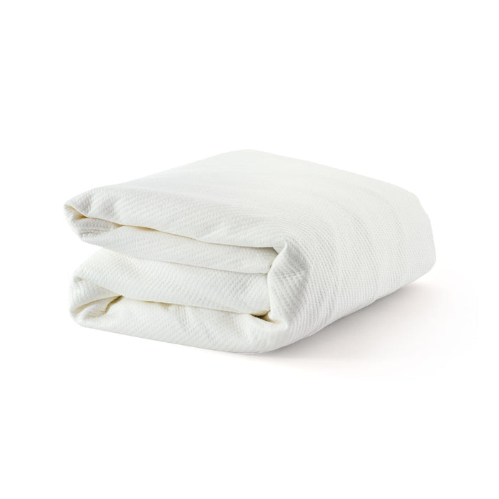 Folded white blanket on white background for cozy home decor.