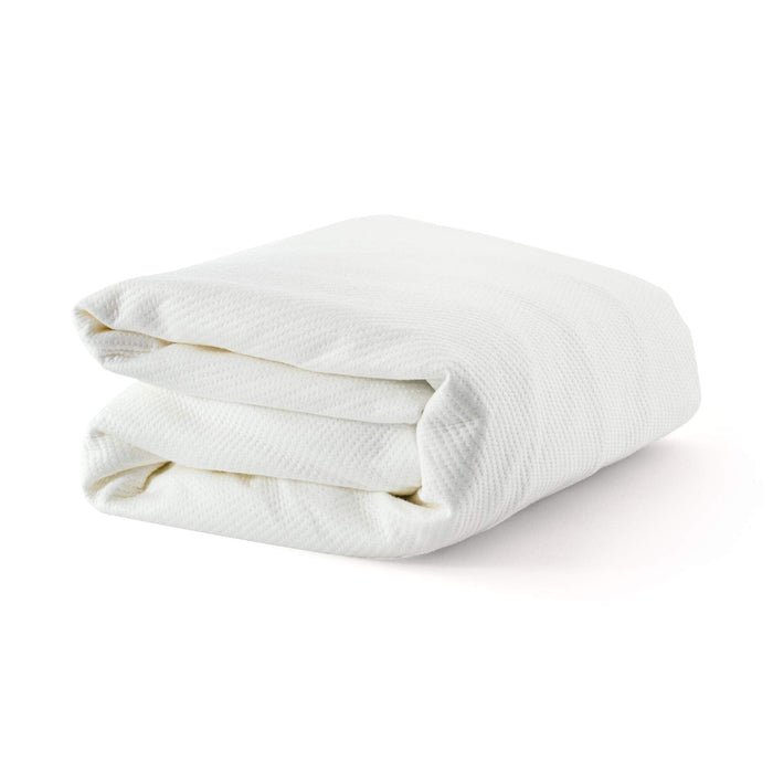 Folded white waffle weave blanket on a white background for home decor.