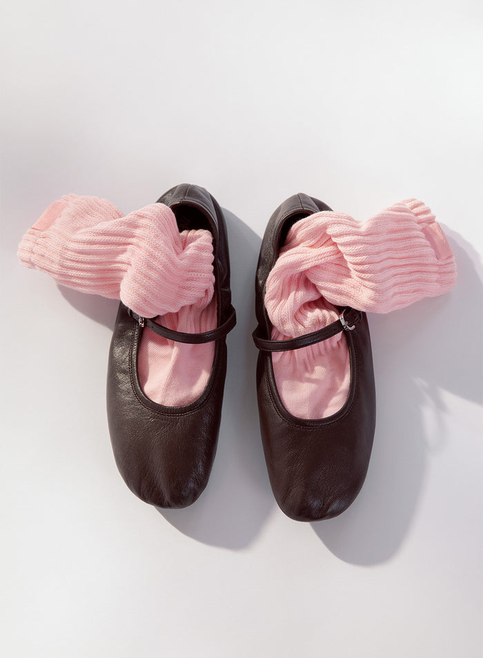 Vaaleanpunaiset aim'n Slouch Socks -sukat asetettuna tummanruskeiden ballerinojen sisään