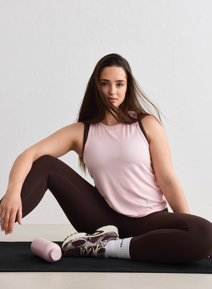 Nainen yllään vaaleanpunainen aim'n Ballerina Soft Basic Singlet istuessaan joogamatolla [L-174cm]