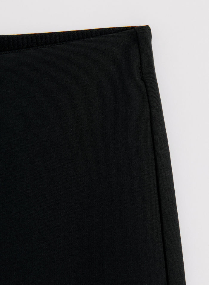 Silkkisen pehmeä musta modaalikangas ja saumayksityiskohta aim'n Luxe Kick Flare Leggings -trikoissa.