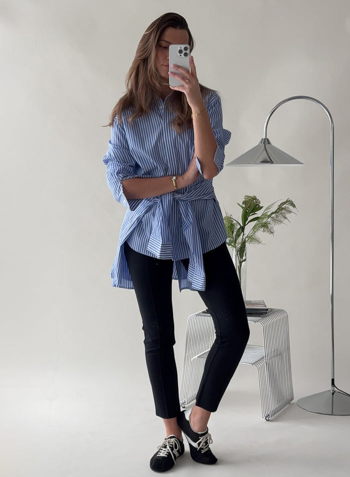 Nainen ottamassa peili-selfietä yllään mustat Luxe Pintuck -housut ja siniraidallinen paita [38-175cm]