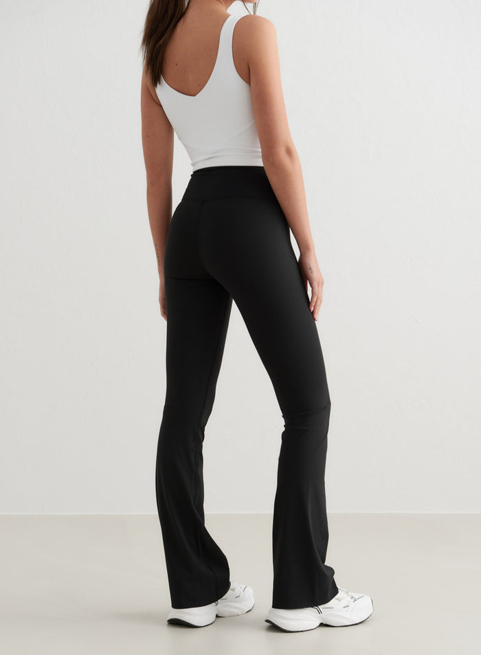 Mustat korkeavyötäröiset aim'n Sense Flare Tights -trikoot levenevillä lahkeilla ja squat proof -kankaalla, takanäkymä.