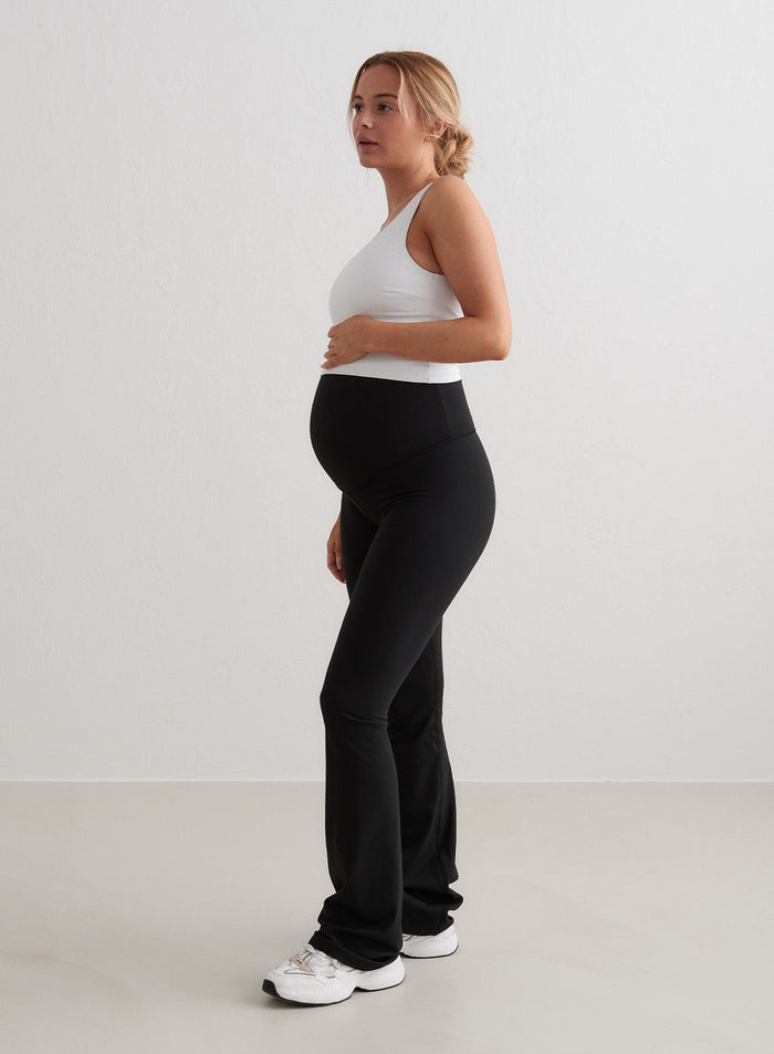 Mustat aim'n Sense Maternity Flare Tights -äitiystrikoot korkealla vyötäröllä ja levenevillä lahkeilla.