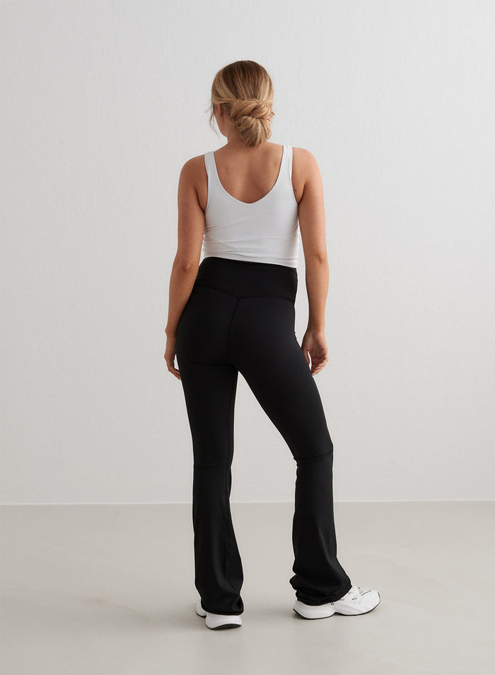 Mustat aim'n Sense Maternity Flare Tights -äitiystrikoot korkealla vyötäröllä ja levenevillä lahkeilla takaapäin.