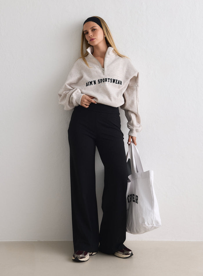 Mallilla päällä Black Sense Pants -housut ja beige poolopaita, kädessään valkoinen kangaskassi [M-170cm]