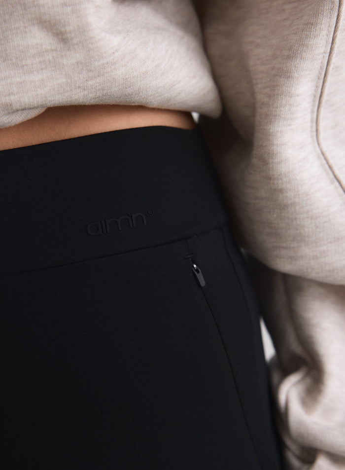 Lähikuva mustista Sense Pants -housuista, joissa on korkea vyötärö aim'n-logolla ja vetoketjullinen tasku [M-170cm]