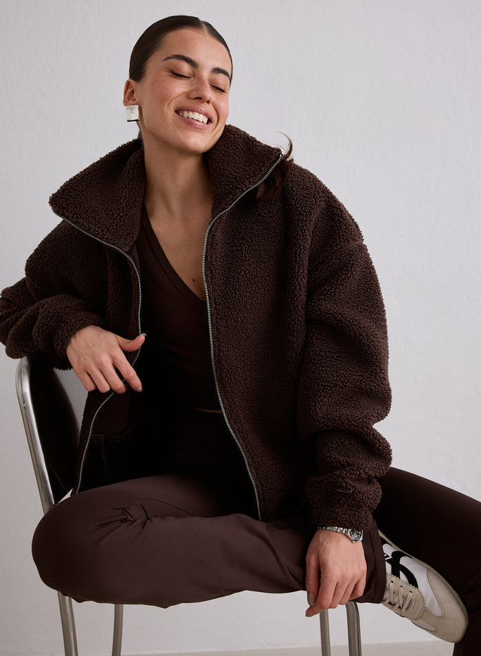 Tuolilla istuva nainen yllään Cacao Pile Jacket merkiltä aim'n [M-174cm]