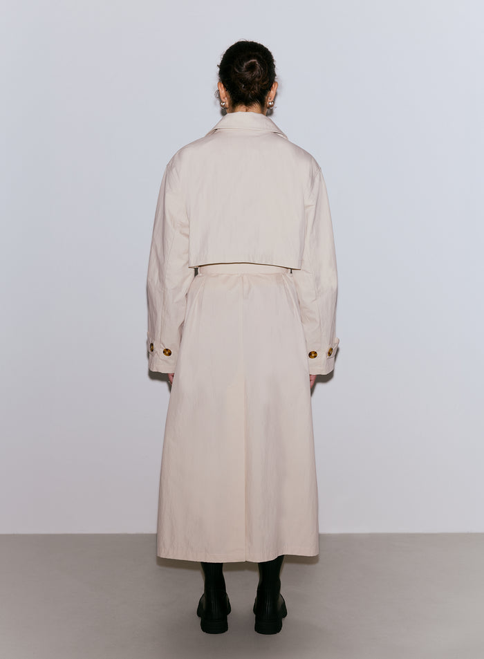 Nainen takaapäin yllään café au lait -värinen Femme Trenchcoat -trenssitakki ja tummat saappaat [M-170cm]