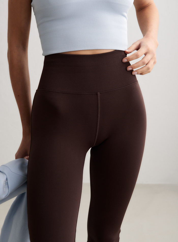 Lähikuva mallista, jolla on yllään Chocolate Shape Seamless Flare Tall -trikoot, ja kuvassa näkyy niiden korkea, ribattu vyötärönauha. [S-174CM]