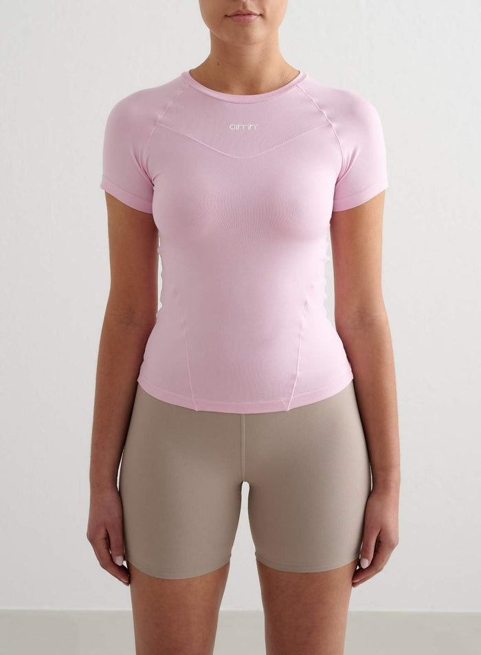 Vaaleanpunainen Soft Basic Short Sleeve -treenipaita merkiltä aim'n pyöreällä pääntiellä ja second skin -tunnulla.