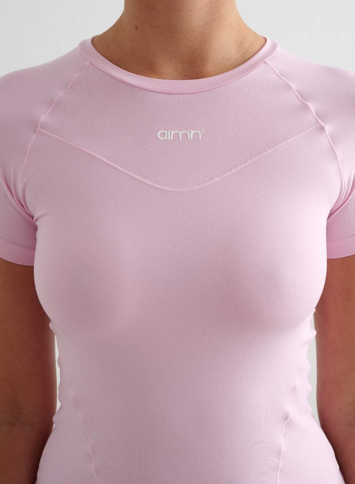 Hattaranvaaleanpunainen Soft Basic Short Sleeve -paita, jossa on pyöreä pääntie ja painettu aim'n-logo.