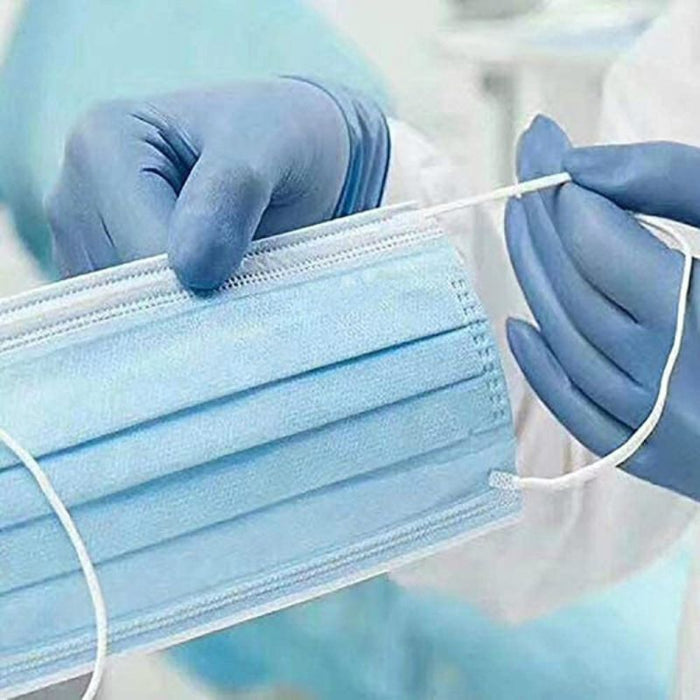 Person wearing blue gloves holding a blue surgical mask.