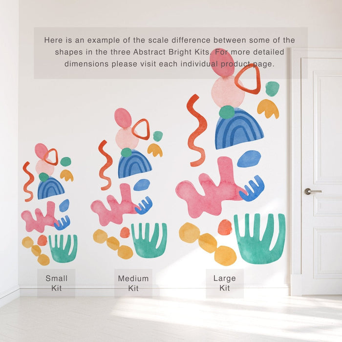 Colorful watercolor abstract wall decals on white wall showing small, medium and large kit size comparison next to door — removable nursery and kids room decor stickers