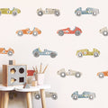 Nursery with pastel vintage race car wall decals, wooden shape sorter toy and pencils on a white stool — kids room decor