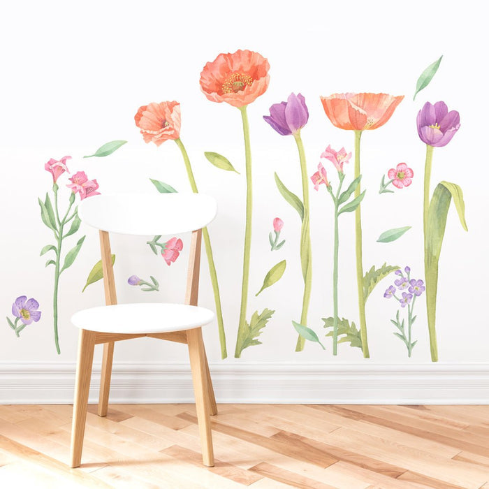 White wooden chair on light hardwood floor in front of watercolor floral wall decals featuring orange poppies and purple tulips