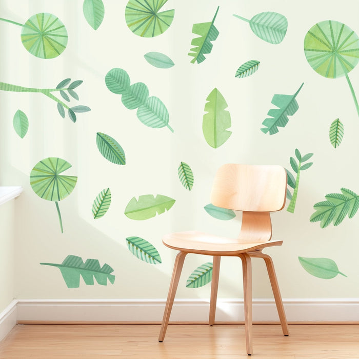 Wooden chair beside green watercolor leaf wall mural on cream wall — botanical wall decals for modern interior decor