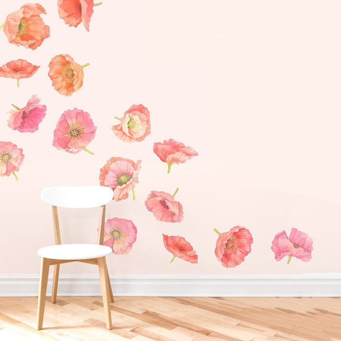 White wooden chair on hardwood floor in front of a pastel pink accent wall decorated with watercolor coral and pink poppy wall decals, feminine nursery and living room floral decor
