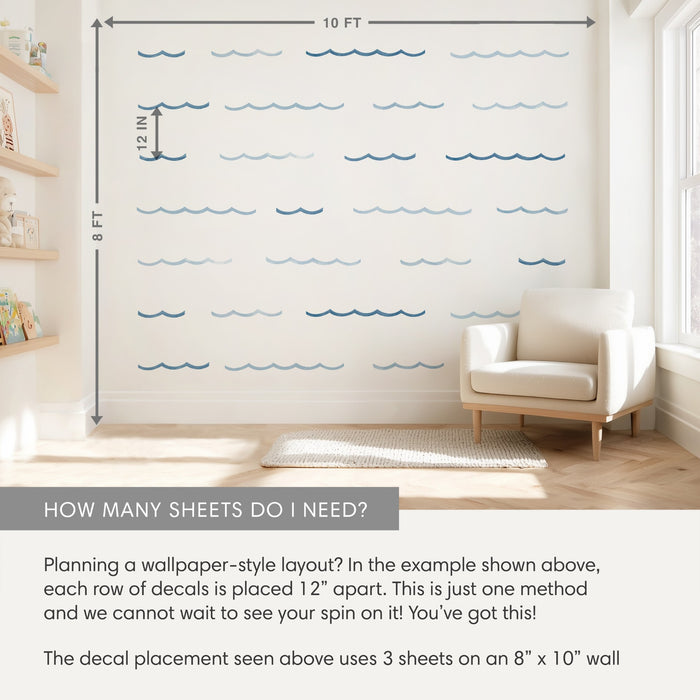 Nautical blue wave wall decals in a wallpaper-style layout on an 8 ft x 10 ft nursery wall, rows spaced 12 in apart, with cream armchair and wooden shelves for scale