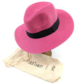 Bright pink, rollling Panama style sun hat (55cm) with 7cm brim, shown with included travel bag for easy packing and storage.