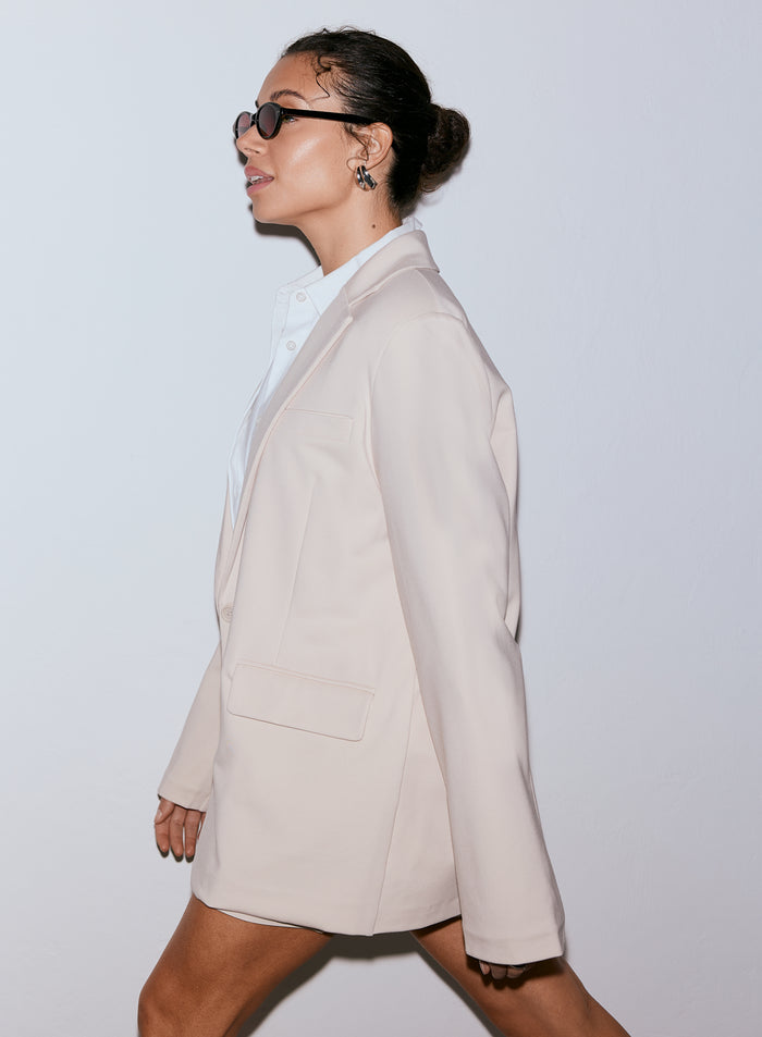 Nainen yllään hiekanvärinen Luxe Relaxed Blazer ja aurinkolasit, katsoo vasemmalle [40-170CM]