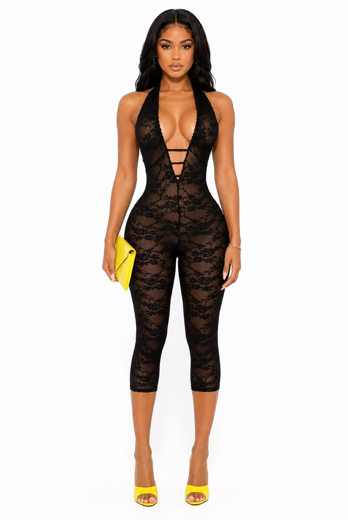 Front view of black sheer lace halter capri romper with plunging neckline, bodycon fit, yellow patent heels, and clutch.