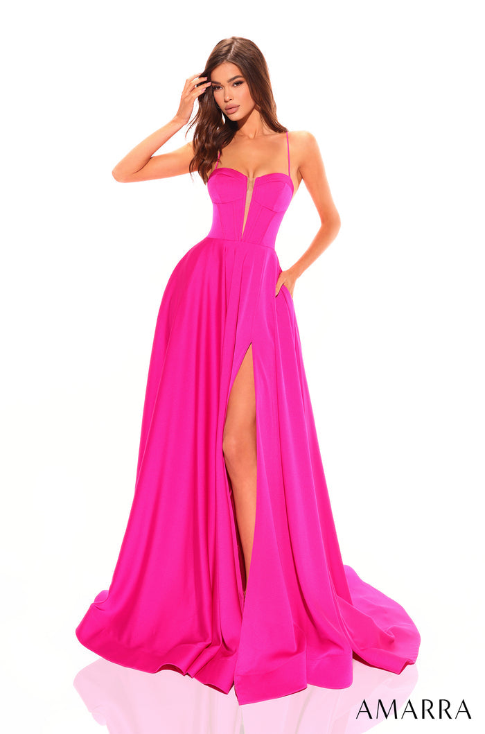 A model wears a floor-length fuchsia gown with a deep V-neckline and high side slit.