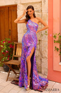 A model wears a one-shoulder Purple/Multi sequined gown with a high slit, posing by stone walls and flowers.
