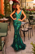 A slender model wears a floor-length emerald sequin mermaid gown with plunging neckline in a cafe setting.