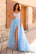 A flowing Light Blue tiered gown with lace bodice and high slit, photographed against a stone wall with wooden doors.