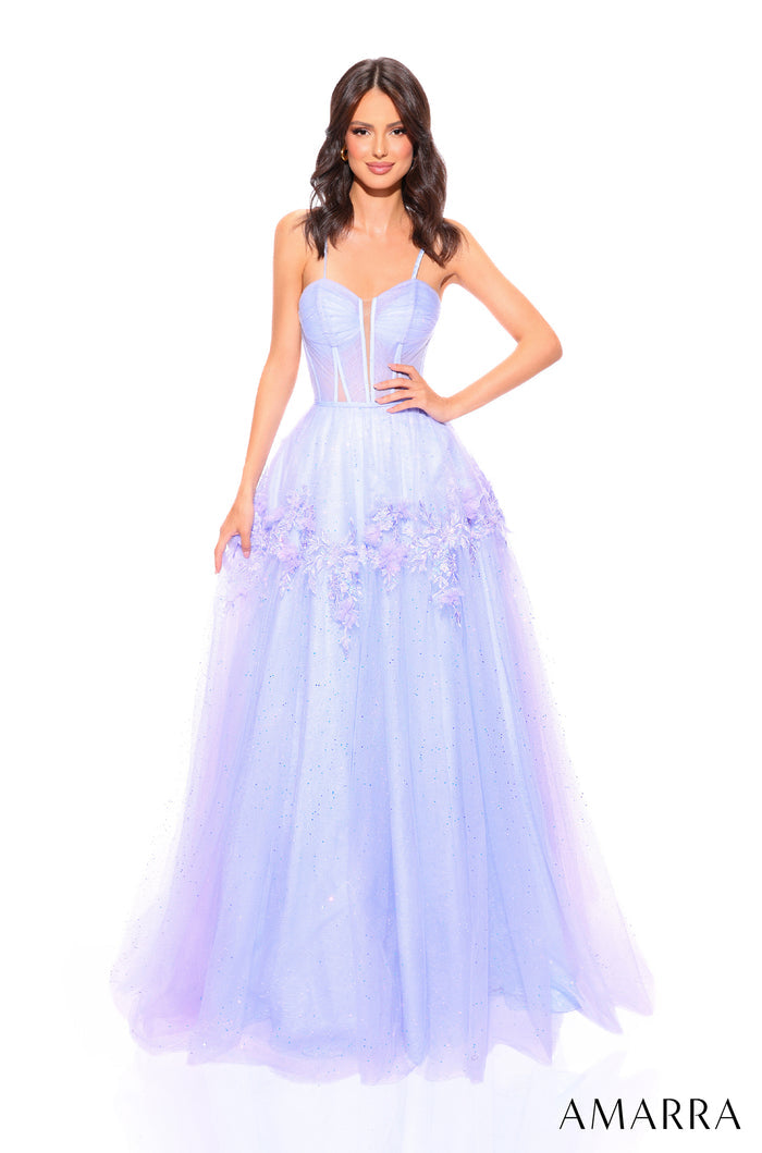A woman wears a periwinkle tulle ball gown with a corset bodice and floral embellishments.