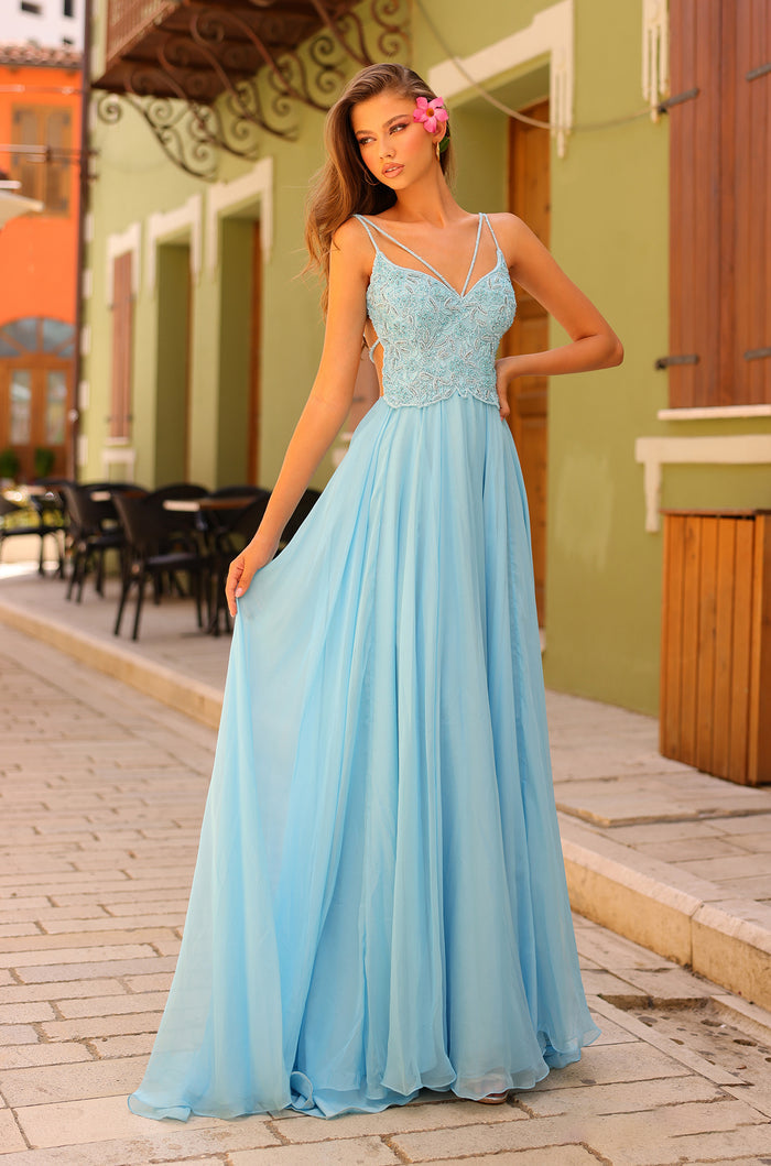 A slender model wears a light blue floor-length gown with an embellished bodice and flowing chiffon skirt.