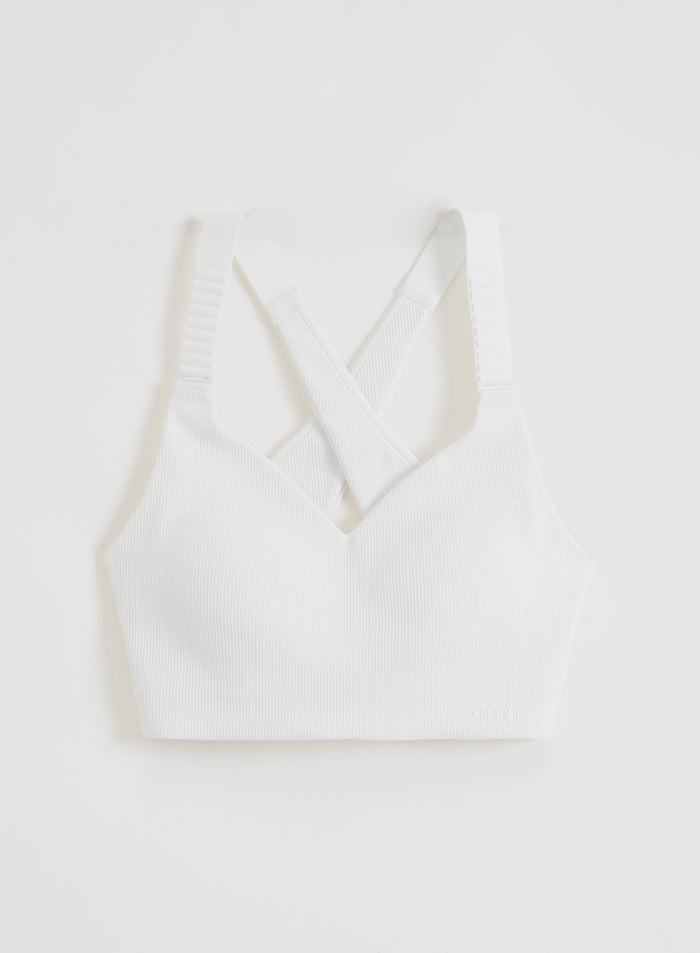 Valkoiset aim'n Ribbed Performance Support Bra -urheiluliivit, joissa on ristikkäiset olkaimet ja V-pääntie flatlay-kuvassa.
