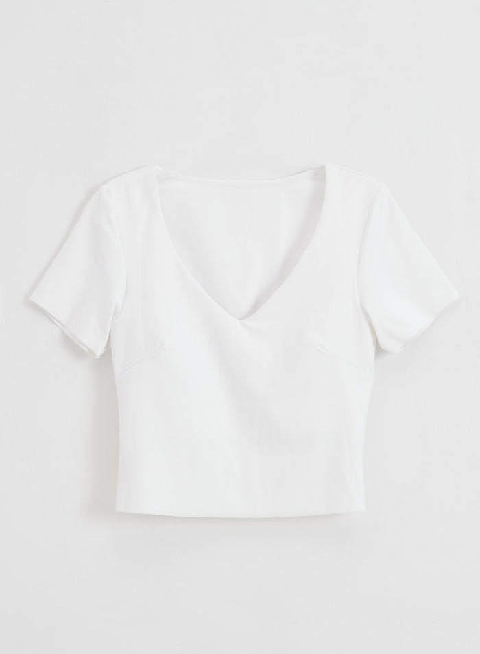 Valkoinen Sense Short Sleeve Bralette V-aukolla ja pehmeällä second skin -tunnulla tasokuvassa.